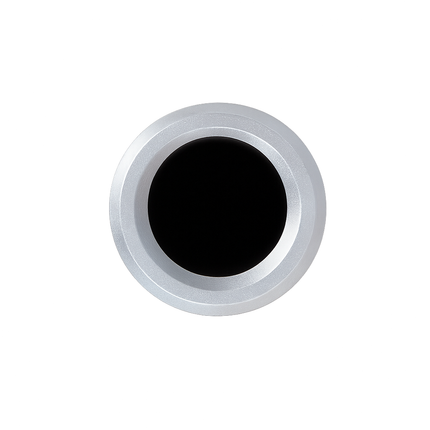 Round metallic object with black center on a white background