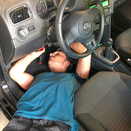 action shot of man using soldering iron in car